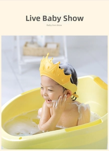 Close-up of baby wearing a crown-shaped yellow silicone shower cap in a warm bath