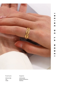 Detail of gold shell-style stainless steel ring with textured relief on model hand