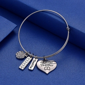 Detailed view of silver teacher charm bracelet with apple and heart shaped pendants