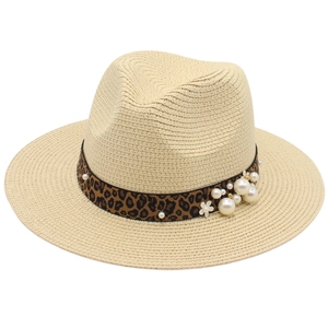 Detail of leopard print band with pearls and floral accents on a beige panama straw hat