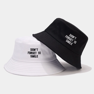 Minimalist black and white bucket hats with 'Don't Forget to Smile' embroidery