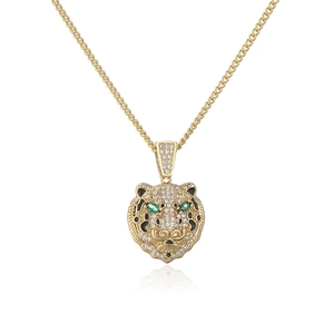 Detail of 18K gold plated leopard head pendant with green zircon eyes on Cuban chain