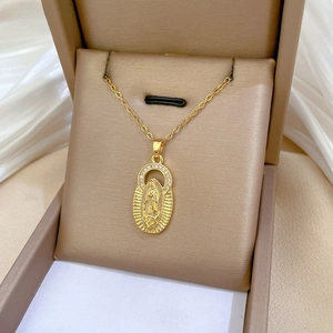 Close-up of gold Virgin Mary pendant with sparkling white zircons on a luxury chain