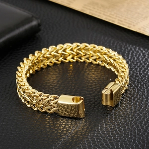 Macro view of golden Franco wheat chain bracelet with a secure mechanical clasp closure