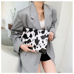 Stylish black and white cow print envelope clutch bag with metal ring and hand strap