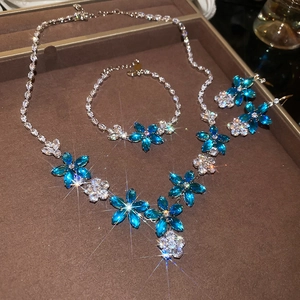 Vue détaillée de l'ensemble de bijoux fleur en zircon avec collier, bracelet et boucles