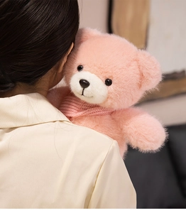 Close-up of a pink teddy bear featuring soft plush fur and a matching knitted scarf