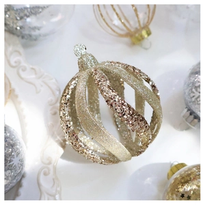 Detail of champagne gold sequined hollow ribbed Christmas ball with shimmering texture