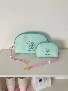 Detail of mint green nylon puppy makeup bags in two sizes with pink zippers