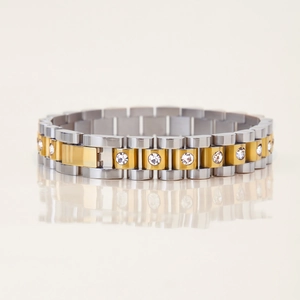 Detail of two-tone 18k gold bracelet with circular white zircon inlays and polished finish