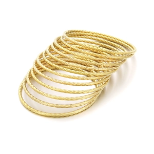 Stackable gold titanium steel bangles with twist rope texture in a layered set
