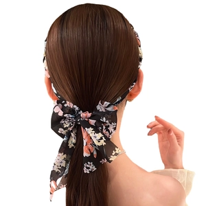 Black floral chiffon hair scarf with long ribbons tied in a bow on a low ponytail