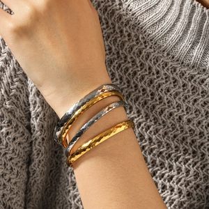 Lot de quatre bracelets joncs en or 18 carats et argent avec texture martelée chic