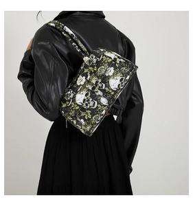 Detailed back view of a black floral skull printed shoulder bag worn on a leather jacket