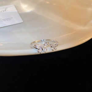 Macro detail of silver adjustable ring featuring dual zirconia butterfly accents