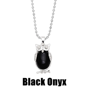 Macro detail of silver owl pendant featuring a large oval black onyx stone inlay