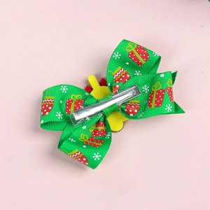 Détail d'une pince à cheveux de Noël verte avec motifs de cadeaux et flocons de neige