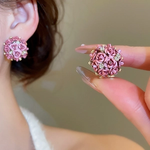 Macro shot of deep pink rose flower stud earrings with sparkling crystal accents