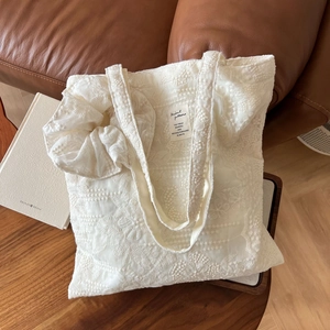 Detailed close-up of white floral embroidery cotton tote bag with a matching scrunchie