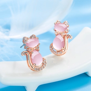 Cute rose gold cat stud earrings with pink quartz and cubic zirconia on soft feather background