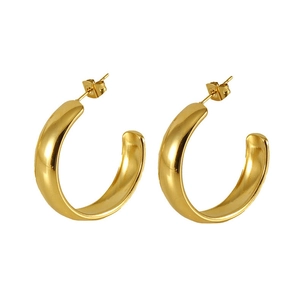 Détail rapproché de boucles d'oreilles créoles dorées en C avec finition polie lisse