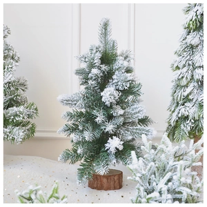 Detail of a mini flocked Christmas tree with realistic snow on a natural cedar wood base