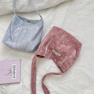 Détail de sacs à bandoulière en velours côtelé bleu et rose avec motifs de cœur et boutons