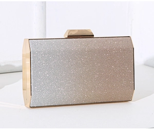Macro shot of gradient glitter fabric and gold metal frame on a rectangular clutch bag