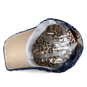 Dettaglio del cappellino in denim con fodera leopardata ed etichetta in puro cotone