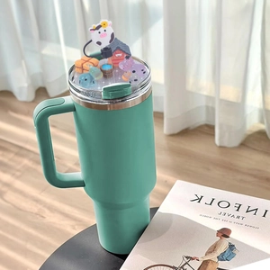 Close-up of a 40oz green tumbler lid with a detailed 3D cartoon farm scene and cow models