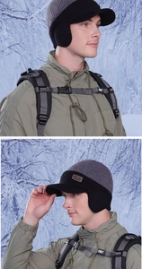 Close-up of winter knit baseball hat with earflaps and leather logo in snow forest