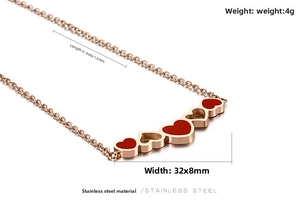 Detail of rose gold stainless steel necklace with five linked red and hollow heart pendants