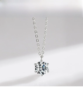 Macro view of a classic six-prong round-cut diamond pendant with a sparkling silver chain