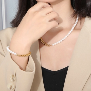 Detail of half pearl half gold Cuban link necklace and bracelet set on model