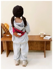 Rear view of a child wearing the red cartoon car nylon waist bag with a grey hoodie
