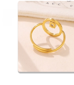 Detailed view of an open adjustable gold ring with a hollow circle and embedded zircon