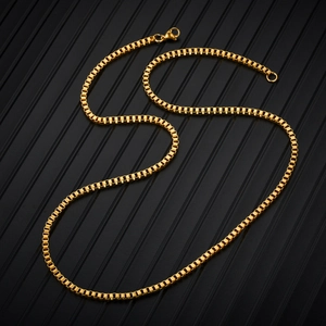 Detail of a golden stainless steel box chain necklace with a lobster clasp on black background