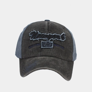 Detailed close-up of distressed denim baseball cap with New York 1985 embroidery