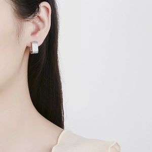 Close-up of sparkling zircon hoop earrings on model for a minimalist silver jewelry look