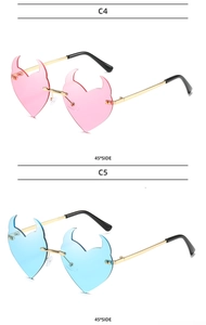 Detail view of pink and blue rimless heart sunglasses with devil horn accents