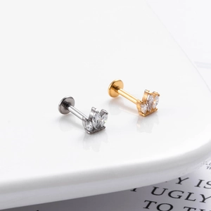 Macro shot of G23 titanium labret studs with marquise zircon flower in silver and gold
