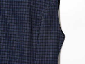 Macro view of stitching and dark blue plaid fabric texture on a casual mini dress