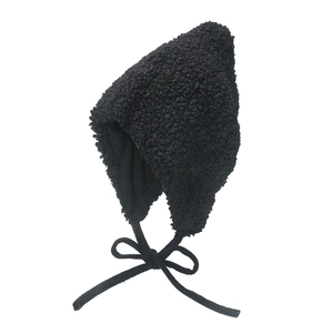 Detail of black faux shearling trapper hat showing cozy lamb wool texture and ear flaps