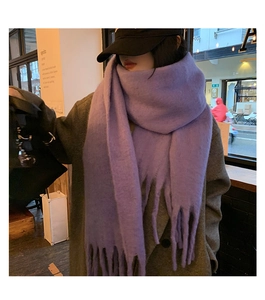 Détail d'une écharpe en mohair violet épais avec franges montrant la texture douce
