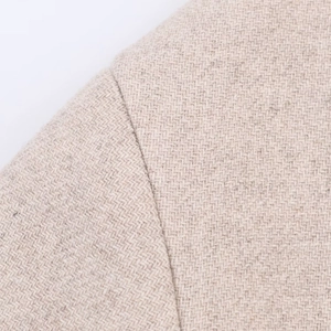 Vista macro dettagliata della cucitura sulla spalla e della trama in tweed del cappotto beige