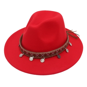 Detail of red fedora hat with bohemian woven band and silver metal pendant charms