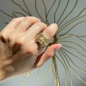 Close-up of gold vine ring featuring woven textures and starry zircon stones on hand