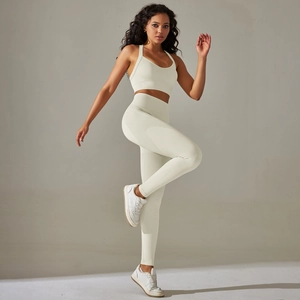 Detail of cross-back sports bra and high-waist seamless leggings in cream white knit