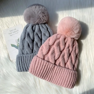 Thick cable knit beanies with faux fur pom-poms in grey and pink for winter