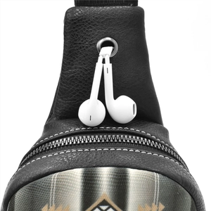 Detail of canvas bag featuring metal earphone port and zipper on black leather fabric